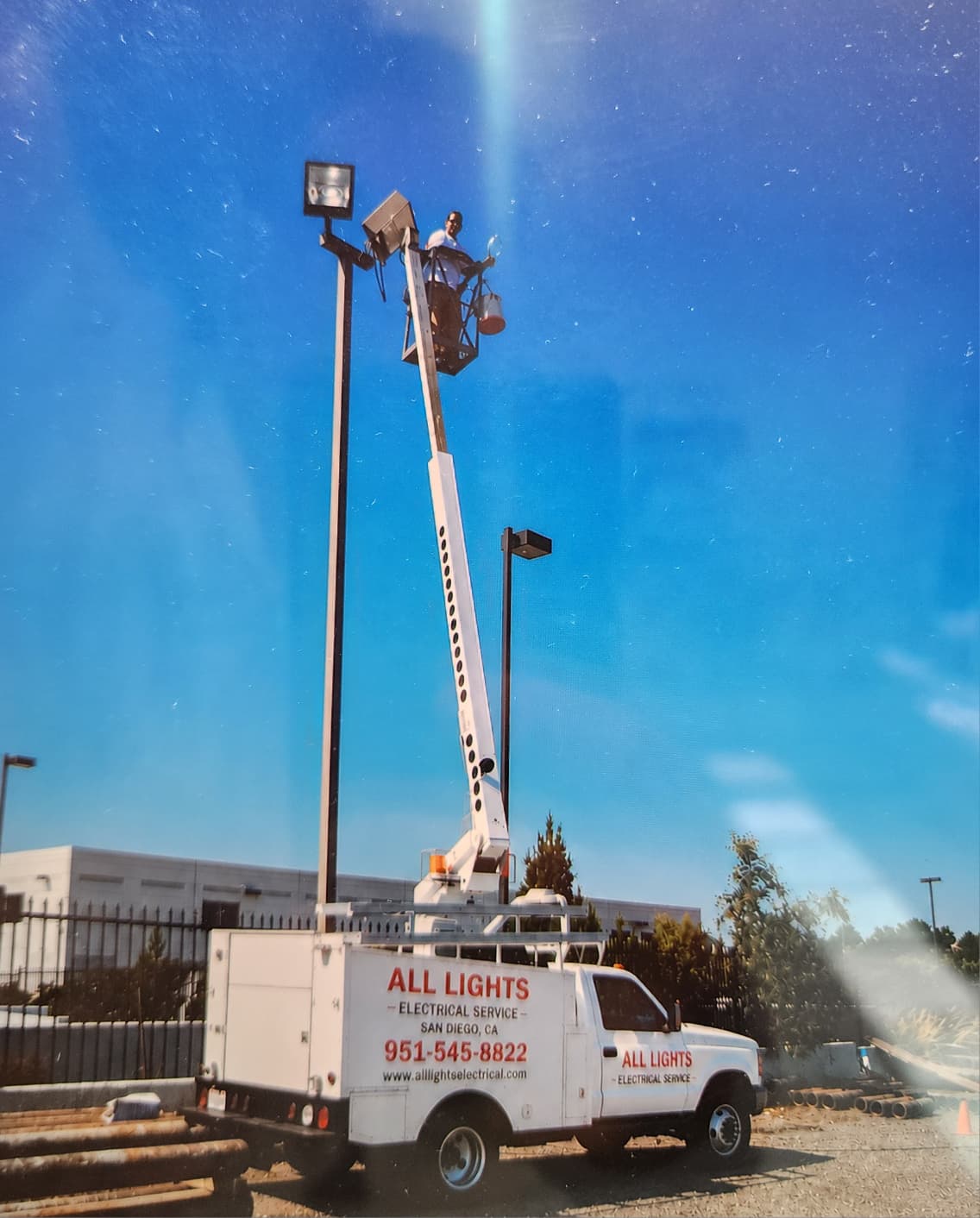 Parking Lot Lighting — Bucket truck servicing parking lot pole light