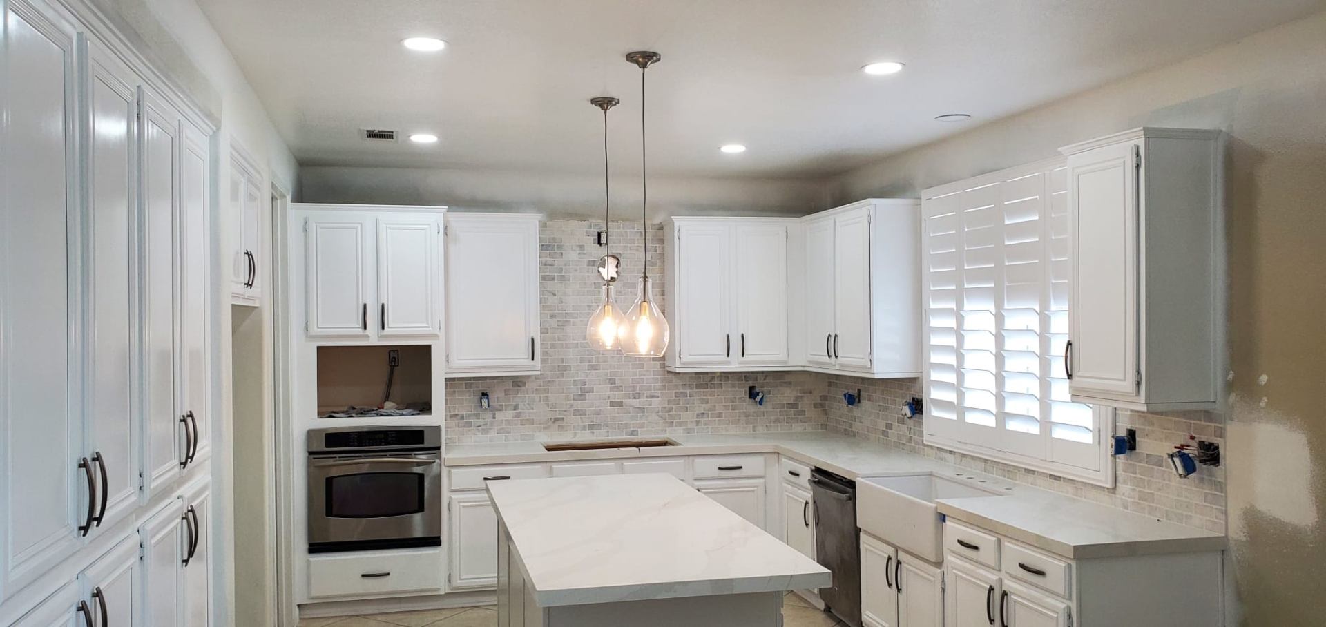 Residential Electrical — White-finish pendant trio over island